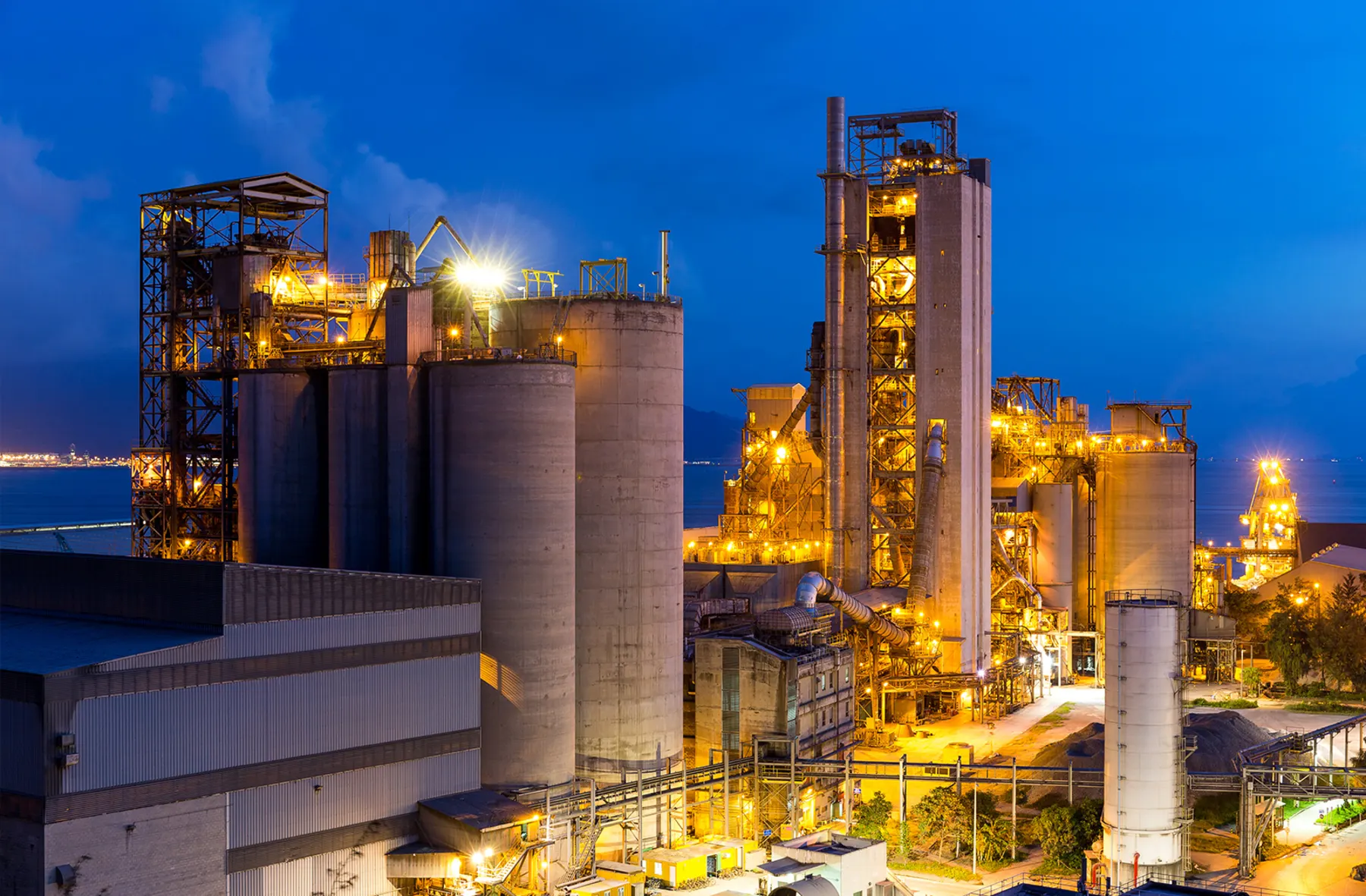 Large energy process plant with illuminated industrial units and storage silos