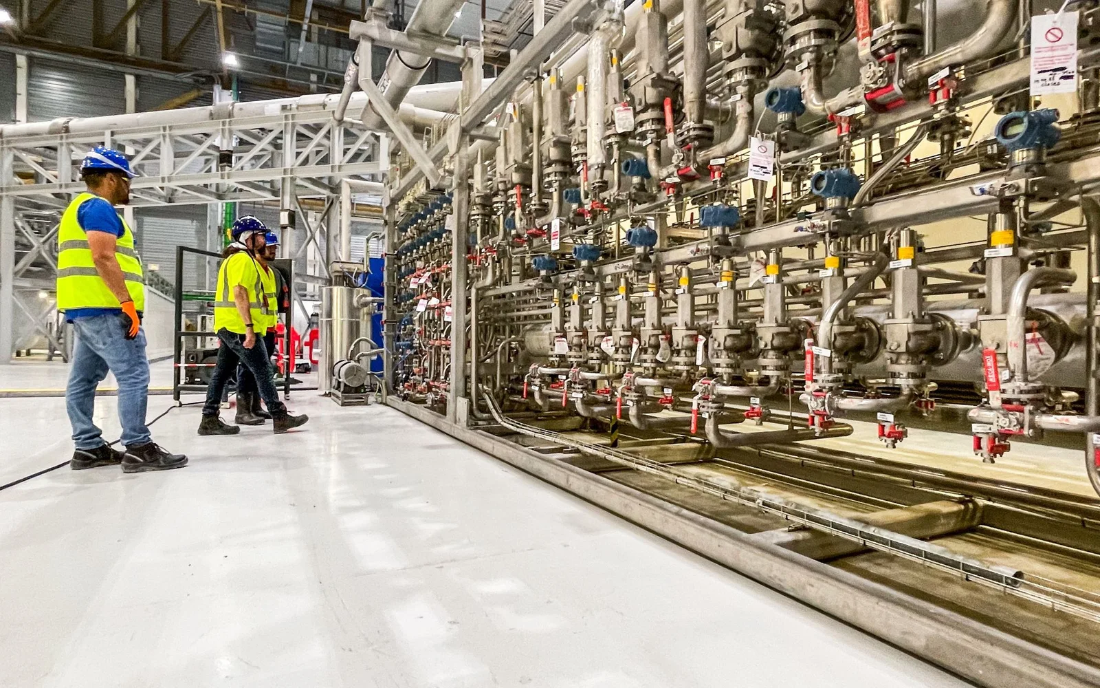 Field team reviewing complex industrial piping and instrumentation