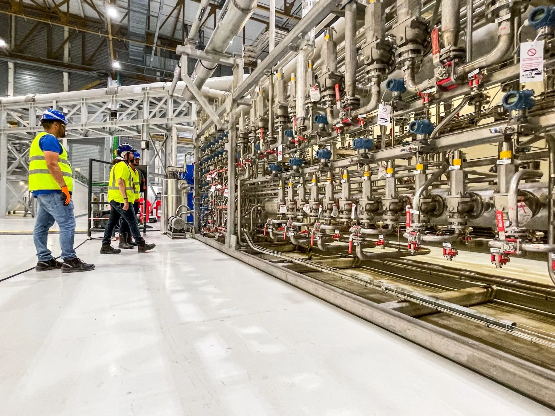 ITER industrial installation with field team reviewing complex piping and instrumentation